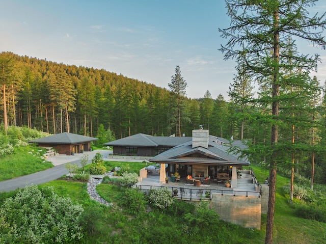 6601 Russian Joe Rd, Missoula, MT 59802 - back of house with a view of trees and a chimney