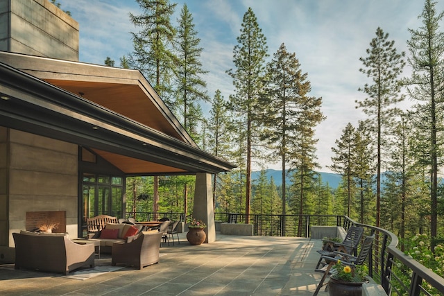 6601 Russian Joe Rd, Missoula, MT 59802 - view of patio / terrace featuring an outdoor living space with a fireplace, a mountain view, and a forest view