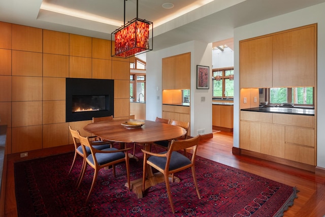 6601 Russian Joe Rd, Missoula, MT 59802 - dining room with dark wood-type flooring, a tray ceiling, a tile fireplace, and a chandelier