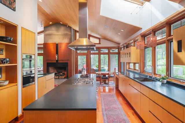 6601 Russian Joe Rd, Missoula, MT 59802 - kitchen featuring island exhaust hood, wooden ceiling, stainless steel gas cooktop, dark countertops, and a fireplace