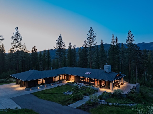 6601 Russian Joe Rd, Missoula, MT 59802 - view of front facade featuring a view of trees, a chimney, and driveway