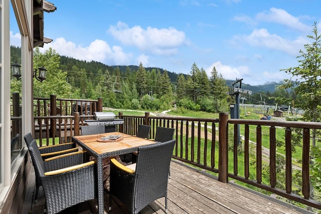 153 Slopeside Dr Unit 14, Whitefish, MT 59937 - wooden deck featuring a wooded view, grilling area, and outdoor dining space