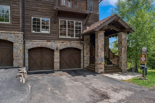 153 Slopeside Dr Unit 14, Whitefish, MT 59937 - view of front of house with a garage, stone siding, and driveway