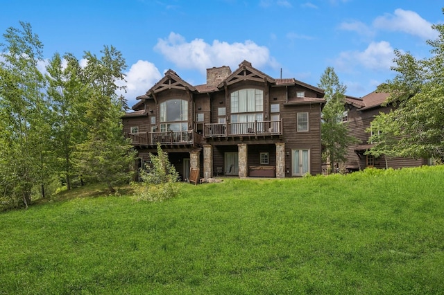 153 Slopeside Dr Unit 14, Whitefish, MT 59937 - back of house featuring a deck, a chimney, a yard, and stone siding