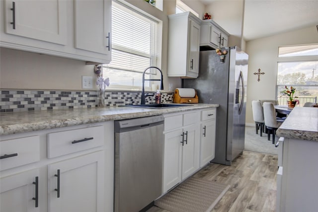 5610 Hauser Damn Rd, Helena, MT 59602 - kitchen featuring stainless steel appliances, light wood-style floors, decorative backsplash, and plenty of natural light
