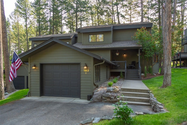 183B Eagle Bend Dr, Bigfork, MT 59911 - mid-century modern home featuring asphalt driveway, an attached garage, roof with shingles, and a front lawn