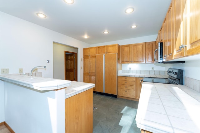 183B Eagle Bend Dr, Bigfork, MT 59911 - kitchen with range with electric stovetop, tile counters, paneled fridge, stainless steel microwave, and recessed lighting