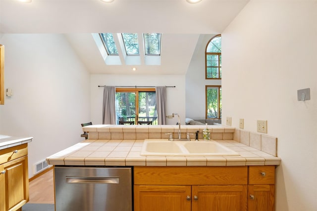 183B Eagle Bend Dr, Bigfork, MT 59911 - kitchen featuring dishwasher, a skylight, wood finished floors, a peninsula, and high vaulted ceiling
