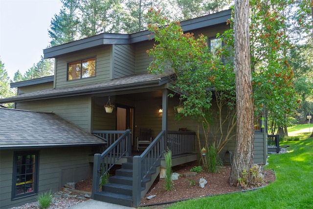 183B Eagle Bend Dr, Bigfork, MT 59911 - mid-century home featuring roof with shingles, covered porch, and a front yard