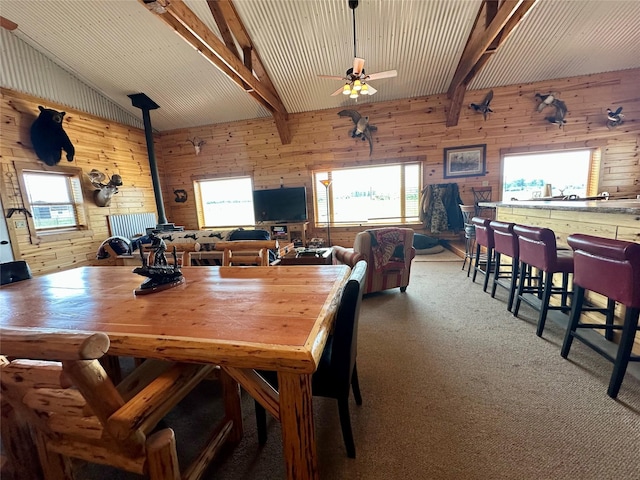 30 Kolbeck Ln, Hall, MT 59837 - dining area featuring a wood stove, healthy amount of natural light, wood walls, a ceiling fan, and carpet flooring