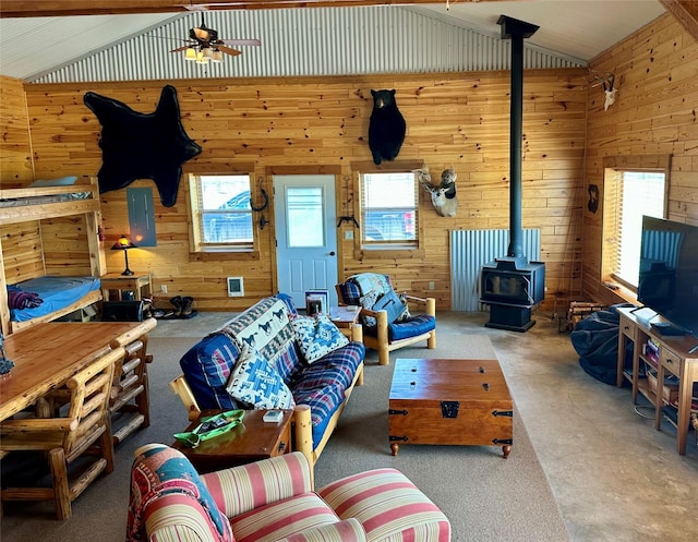 30 Kolbeck Ln, Hall, MT 59837 - living room featuring vaulted ceiling, a wood stove, wood walls, a ceiling fan, and plenty of natural light