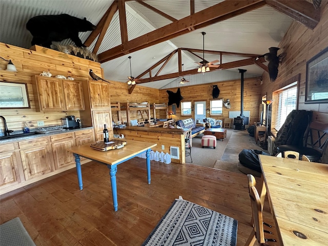 30 Kolbeck Ln, Hall, MT 59837 - dining space with a wood stove, wood walls, plenty of natural light, high vaulted ceiling, and dark wood-style floors