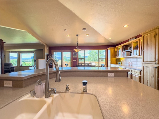 3640 Jack Dr, Missoula, MT 59803 - kitchen with plenty of natural light, recessed lighting, decorative backsplash, hanging light fixtures, and glass insert cabinets
