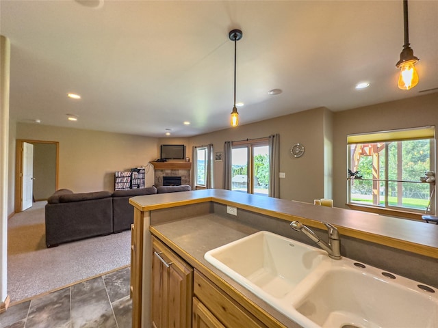 3640 Jack Dr, Missoula, MT 59803 - kitchen featuring a tiled fireplace, pendant lighting, recessed lighting, dark colored carpet, and open floor plan