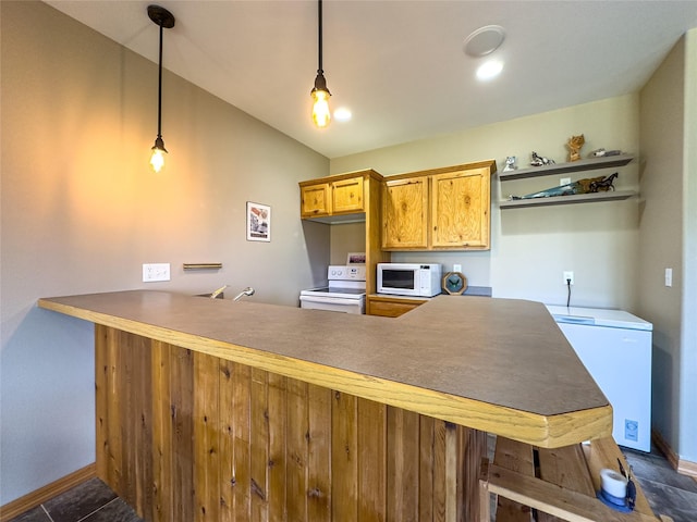 3640 Jack Dr, Missoula, MT 59803 - kitchen featuring white appliances, a peninsula, vaulted ceiling, and hanging light fixtures