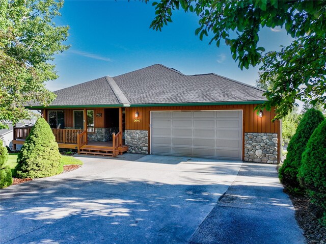 3640 Jack Dr, Missoula, MT 59803 - view of front facade featuring stone siding, a shingled roof, an attached garage, and driveway
