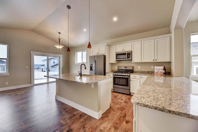 2909 Travis Ave, Helena, MT 59601 - kitchen with stainless steel appliances, vaulted ceiling, light wood-type flooring, white cabinets, and light stone countertops