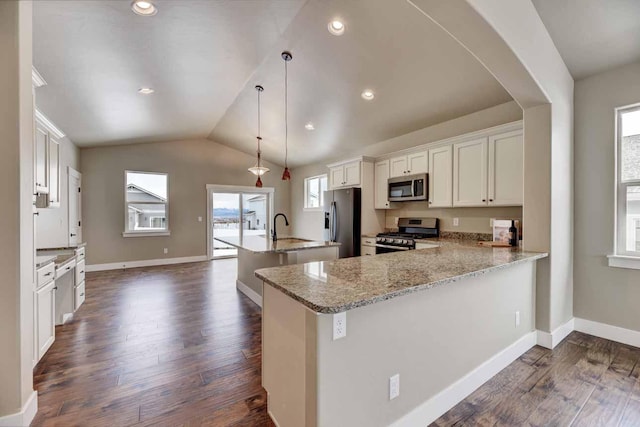 2909 Travis Ave, Helena, MT 59601 - kitchen featuring stainless steel appliances, dark wood-type flooring, an island with sink, vaulted ceiling, and arched walkways