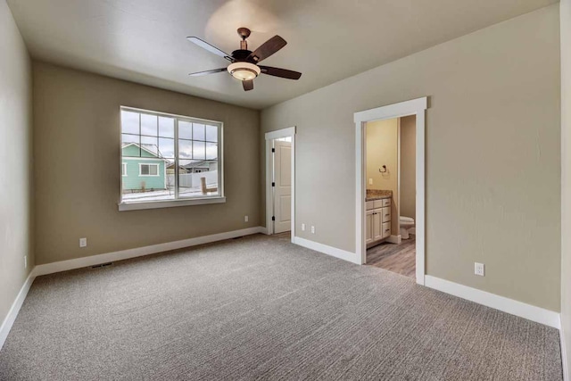 2909 Travis Ave, Helena, MT 59601 - unfurnished bedroom with light carpet, connected bathroom, and ceiling fan