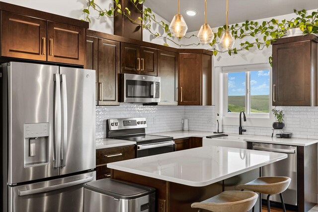 7070 Max Dr, Missoula, MT 59803 - kitchen featuring stainless steel appliances, a kitchen breakfast bar, light countertops, tasteful backsplash, and a center island