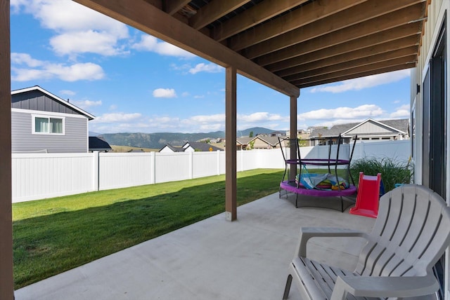 7070 Max Dr, Missoula, MT 59803 - fenced backyard with a trampoline, a patio area, and a mountain view