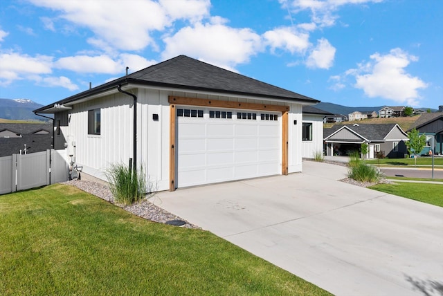 7070 Max Dr, Missoula, MT 59803 - view of front of home with concrete driveway, a shingled roof, a garage, a mountain view, and a gate