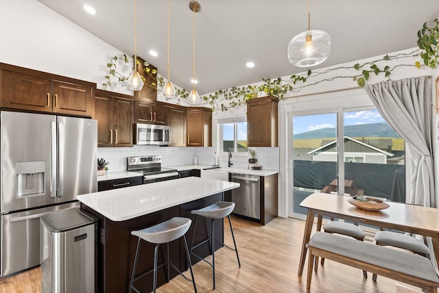 7070 Max Dr, Missoula, MT 59803 - kitchen with stainless steel appliances, a center island, light countertops, decorative backsplash, and pendant lighting