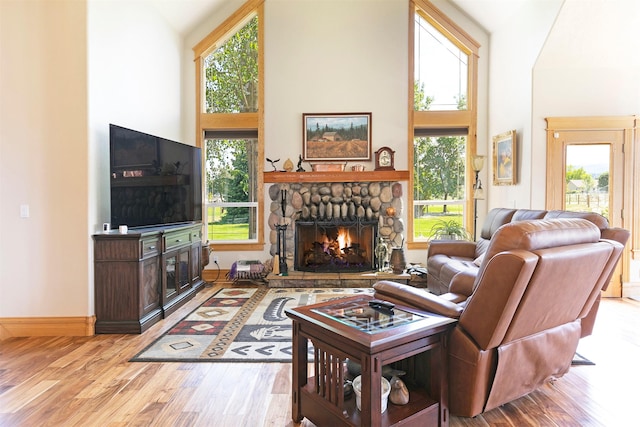 424 Saddle Ridge Rd, Hamilton, MT 59840 - living room with a stone fireplace, wood finished floors, high vaulted ceiling, and healthy amount of natural light