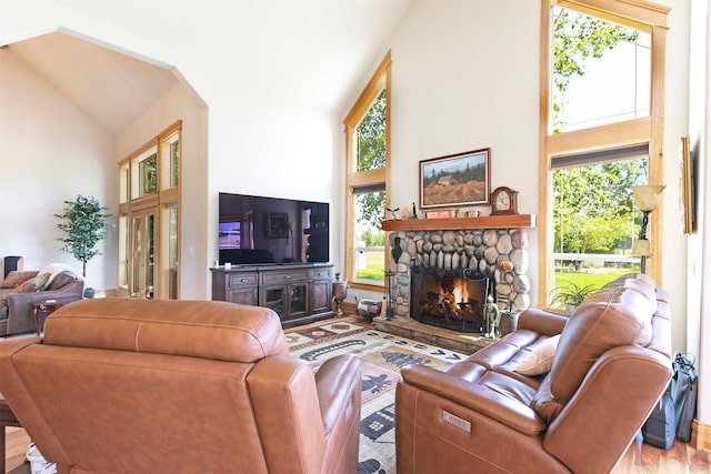 424 Saddle Ridge Rd, Hamilton, MT 59840 - living room with high vaulted ceiling, wood finished floors, a stone fireplace, and arched walkways