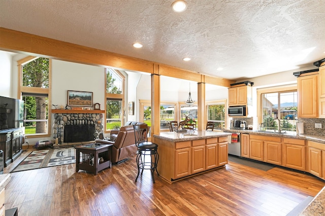 424 Saddle Ridge Rd, Hamilton, MT 59840 - kitchen featuring stainless steel appliances, a fireplace, a textured ceiling, dark wood finished floors, and open floor plan