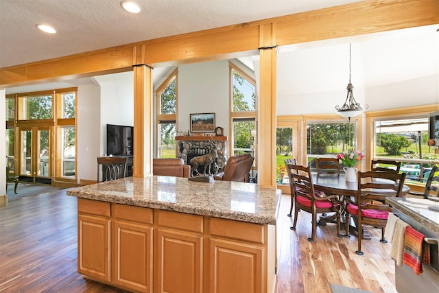 424 Saddle Ridge Rd, Hamilton, MT 59840 - kitchen with light wood-style flooring, recessed lighting, open floor plan, light stone countertops, and a stone fireplace