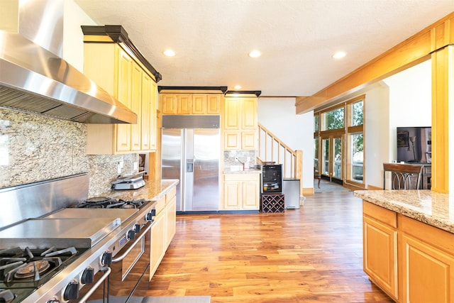 424 Saddle Ridge Rd, Hamilton, MT 59840 - kitchen featuring appliances with stainless steel finishes, wall chimney exhaust hood, light wood-type flooring, tasteful backsplash, and recessed lighting