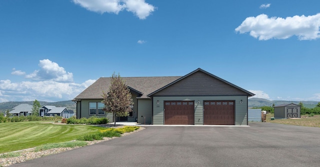 2110 Spring Wheat Loop, East Helena, MT 59635 - view of front of home featuring a storage shed, an attached garage, a front lawn, and driveway
