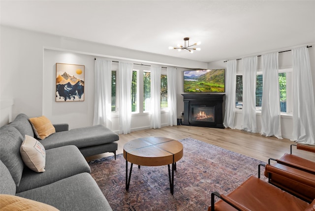128 Mallard Loop, Whitefish, MT 59937 - living area with wood finished floors, a glass covered fireplace, and a chandelier
