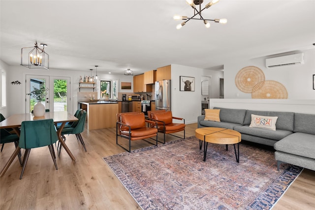 128 Mallard Loop, Whitefish, MT 59937 - living room featuring a chandelier, a wall mounted air conditioner, and light wood-style floors