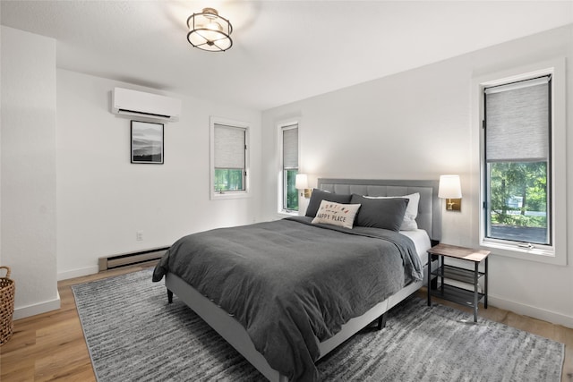 128 Mallard Loop, Whitefish, MT 59937 - bedroom featuring a wall unit AC, baseboard heating, and light wood finished floors
