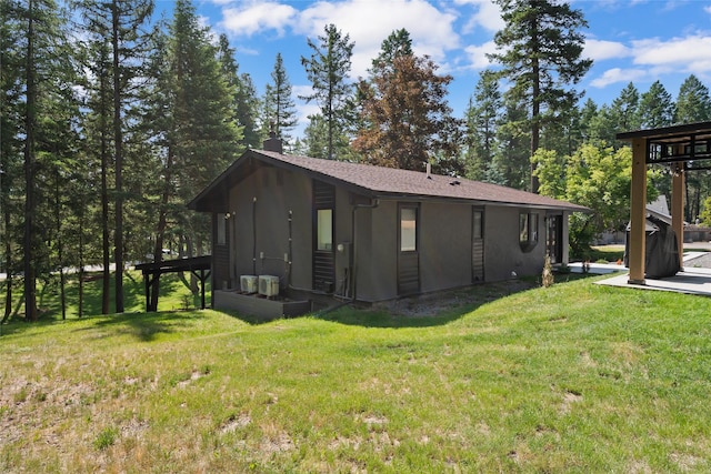128 Mallard Loop, Whitefish, MT 59937 - view of property exterior with a yard, a chimney, and stucco siding