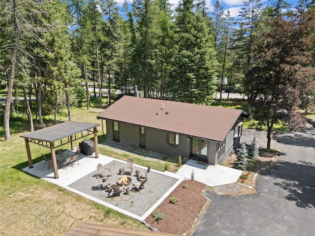 128 Mallard Loop, Whitefish, MT 59937 - view of front of property with a fire pit, a patio area, roof with shingles, stucco siding, and a front yard