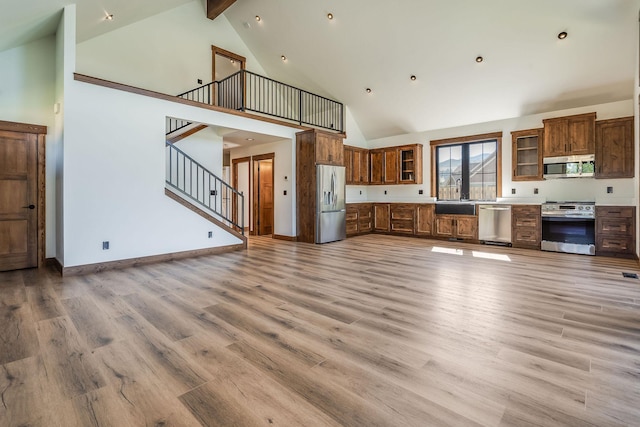 309 Stanton St, Plains, MT 59859 - kitchen with stainless steel appliances, high vaulted ceiling, glass insert cabinets, open floor plan, and light countertops