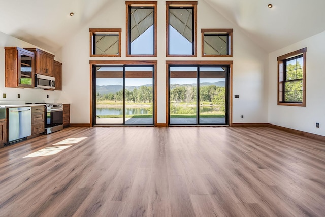 309 Stanton St, Plains, MT 59859 - unfurnished living room with high vaulted ceiling, light wood finished floors, and a water view