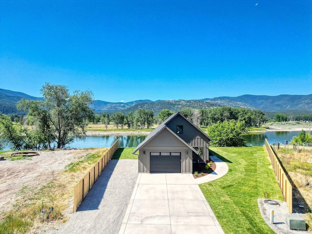 309 Stanton St, Plains, MT 59859 - view of front of property featuring a water and mountain view, board and batten siding, driveway, and a garage