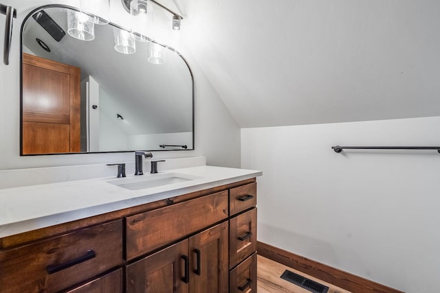 309 Stanton St, Plains, MT 59859 - bathroom featuring vaulted ceiling, vanity, and wood finished floors