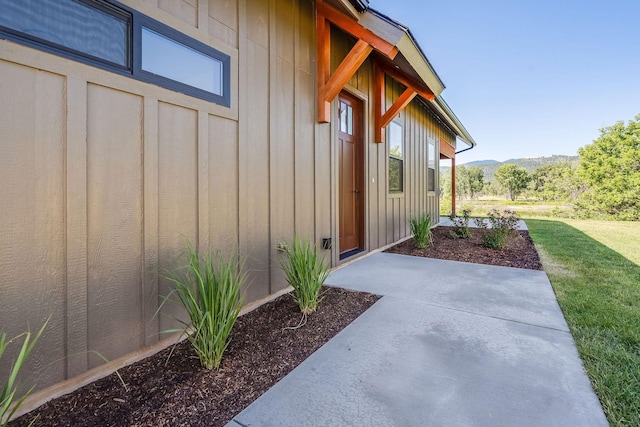 309 Stanton St, Plains, MT 59859 - property entrance featuring board and batten siding, a patio, a yard, and a mountain view