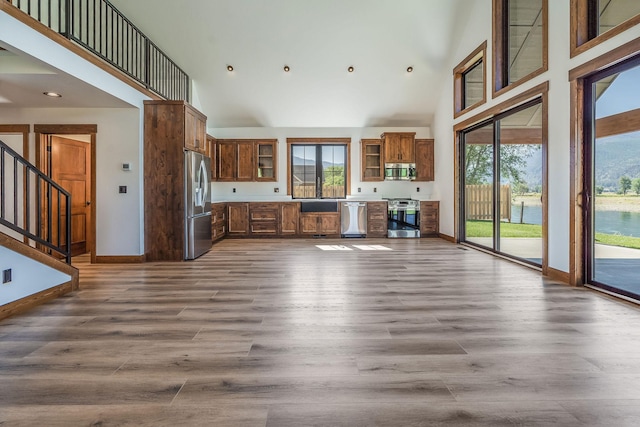 309 Stanton St, Plains, MT 59859 - unfurnished living room with high vaulted ceiling, plenty of natural light, dark wood-type flooring, stairs, and recessed lighting