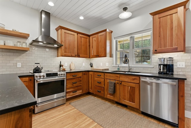 1219 Lolo St, Missoula, MT 59802 - kitchen with stainless steel appliances, wall chimney exhaust hood, light wood-style floors, tasteful backsplash, and recessed lighting