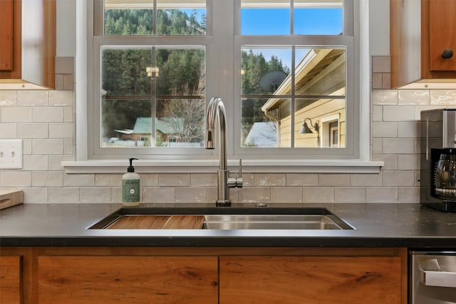 1219 Lolo St, Missoula, MT 59802 - kitchen featuring brown cabinetry, dark countertops, backsplash, and dishwasher
