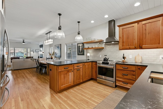 1219 Lolo St, Missoula, MT 59802 - kitchen featuring wall chimney exhaust hood, stainless steel appliances, a peninsula, light wood-style floors, and brown cabinetry