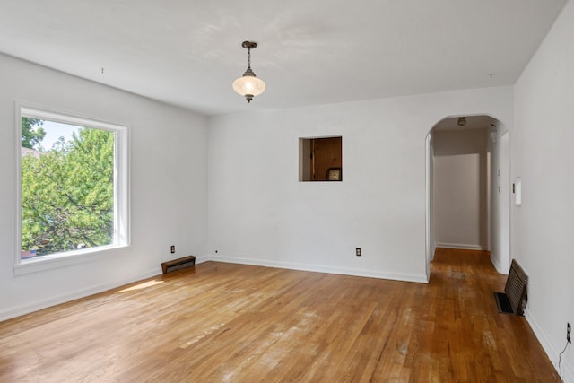 2515 S Higgins Ave, Missoula, MT 59801 - spare room with arched walkways, healthy amount of natural light, and light wood-style floors