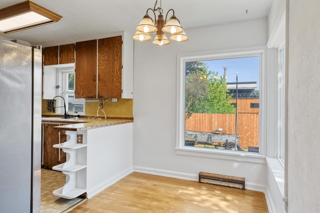2515 S Higgins Ave, Missoula, MT 59801 - kitchen with freestanding refrigerator, open shelves, a chandelier, light wood-type flooring, and brown cabinetry