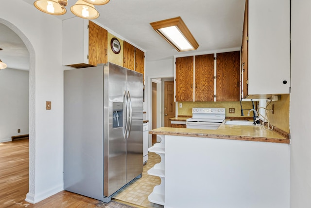 2515 S Higgins Ave, Missoula, MT 59801 - kitchen with stainless steel refrigerator with ice dispenser, electric stove, light countertops, open shelves, and arched walkways